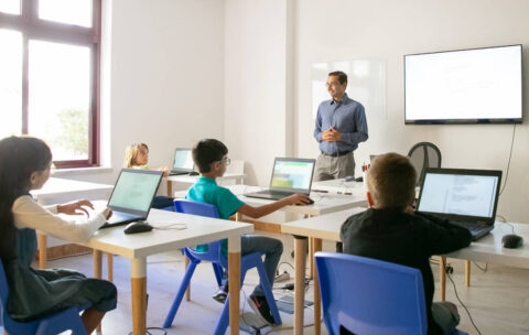 Confident teacher explaining lesson to pupils
